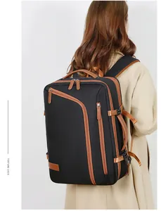 Detail of travel backpack with black fabric, brown leather trim, and side handle