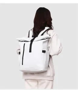 Vue arrière d'un mannequin portant un sac à dos blanc à toit enroulé, imperméable