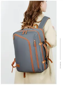 Side view of dark gray travel backpack with brown leather accents on male model
