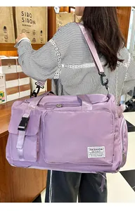 Vista laterale dettagliata della borsa da viaggio viola indossata da una modella in negozio