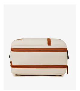 Side view of white canvas travel backpack showing multiple storage layers and brown zippers