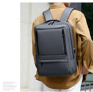 Man wearing charcoal grey waterproof laptop backpack with external USB charging port