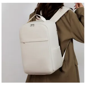 Minimalist beige leather laptop backpack with top handle and metal zippers shown on a model