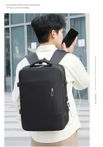Détail du sac à dos de voyage noir montrant le port de charge USB et la sangle réglable
