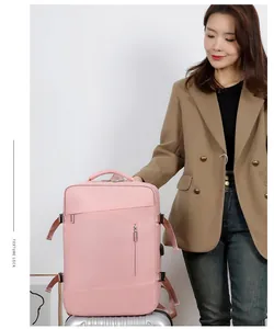 Sac à dos de voyage rose posé sur une valise argentée avec détail de fixation trolley