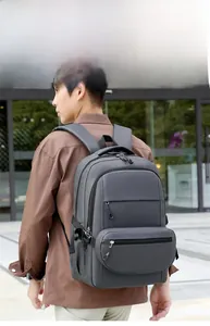 Detail of grey water-resistant laptop backpack with secure side buckles and front zipper pocket
