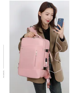 Détail d'un sac à dos rose étanche montrant le port de charge USB et la boucle latérale