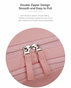 Detail of pink travel backpack featuring dual silver zippers with long fabric pullers