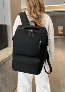 Rear view of model wearing a large black travel backpack with side compression straps