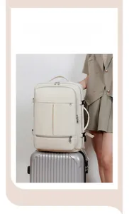 Detail of the cream travel backpack secured to a luggage handle via back strap