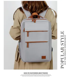 Detailed back view of a light grey business backpack with premium brown leather accents