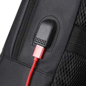 Waterproof business laptop backpack featuring an external USB charging port and red cable