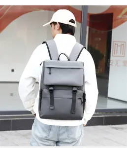 Outdoor view of a man wearing a large dark gray waterproof travel laptop backpack