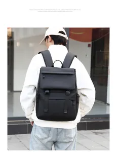 Man wearing a large black travel backpack with clip buckle and matte finish exterior