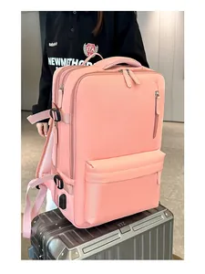 Pink travel backpack on suitcase featuring USB charging port and multiple storage layers