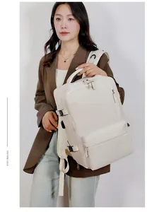 Model wearing a large cream travel backpack with multi-functional pockets and side straps