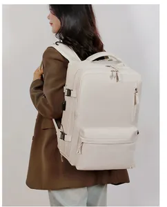 Detail of beige travel backpack featuring side buckles and external USB charging port