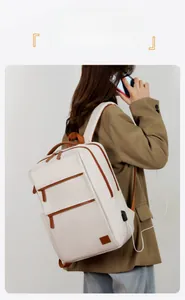 White laptop backpack with brown trim showing the side USB charging port and sleek design