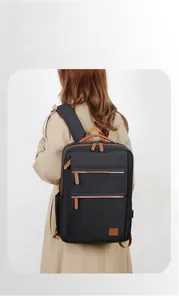 Detail of a black business backpack with leather accents and multiple zipper pockets