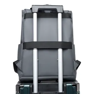 Grey business travel backpack with luggage strap secured on a suitcase handle