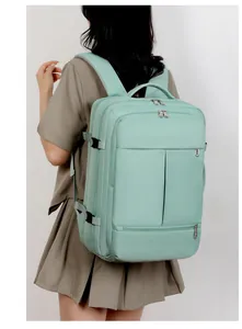 Rear view of mint green waterproof travel backpack with adjustable compression straps