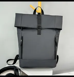 Detail of dark grey waterproof roll-top backpack with dual front zippers and buckle closure