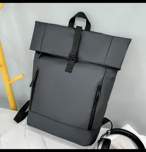 Detail view of water-resistant matte fabric and vertical buckle strap on grey rolltop backpack