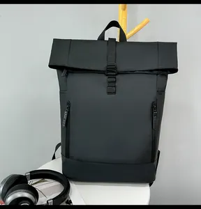 Detail of black roll-top backpack with waterproof matte finish and front buckle closure