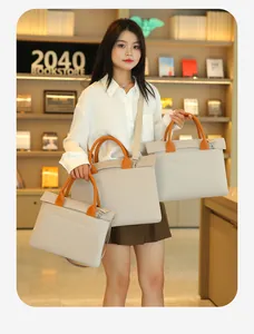 Three sizes of beige business briefcases shown with orange handles in a bookstore setting