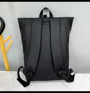 Detail view of the padded shoulder straps and matte waterproof fabric on black backpack