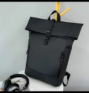 Detail of waterproof matte black roll-top backpack with buckle closure and side pockets