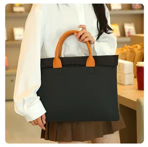 Close-up of briefcase showing large capacity black nylon fabric and orange leather handle