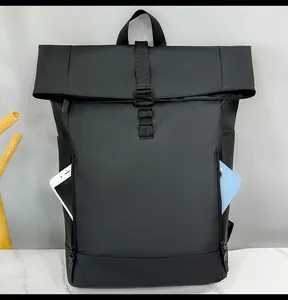 Detail of the side zipper pocket on a black roll-top backpack holding two smartphones