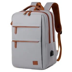 Grey commuter laptop backpack with brown leather accents and external USB charging port