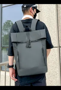 Detail of waterproof roll-top backpack with buckle closure and vertical zippers in city setting