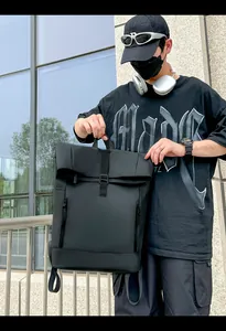 Detail of waterproof black roll-top backpack with buckle and side zippers for commuting