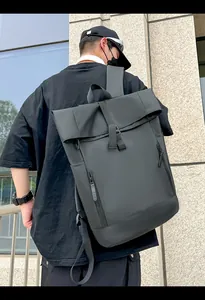 Detailed view of black roll-top waterproof backpack with vertical zipper pockets