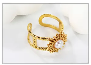 Detail of adjustable gold ring with sunburst design and central white pearl inlay