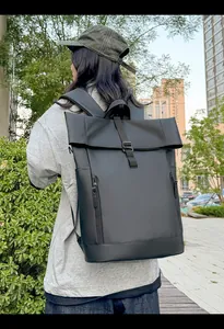 Outdoor shot showing the large black roll-top waterproof backpack for city commuters