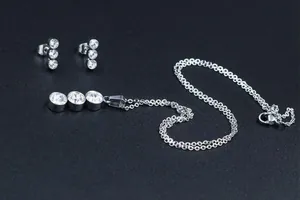 Detailed view of silver stainless steel jewelry set with three round zirconia stones