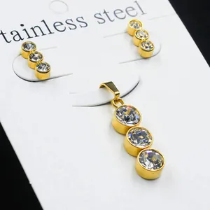 Detail view of gold stainless steel jewelry set with three graduated white zircon stones