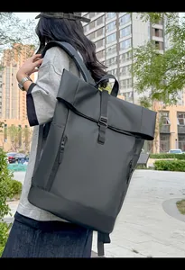 Detail view of black waterproof roll-top backpack with buckle closure for outdoor travel