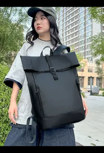 Detail of waterproof matte black roll-top backpack with front zipper and reinforced bottom