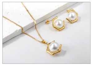 Details von elegantem Edelstahl-Schmuckset in Gold mit weißen Perlen und Ohrringen