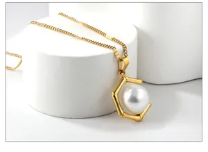 Detail einer eleganten goldenen geometrischen Perlenkette mit großem Perlenanhänger