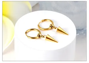 Close-up of gold polished stainless steel hoop earrings with cone pendant on white pedestal