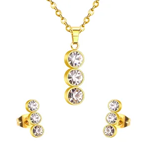 Elegant gold-plated jewelry set featuring three round white crystals on a necklace and studs