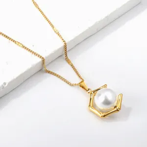 Elegante goldene Perlenkette mit sechseckigem Anhänger auf Stein-Display