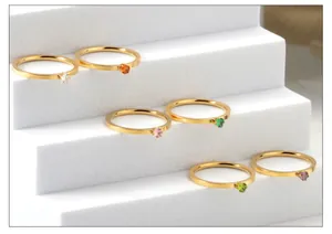 Dettaglio di anelli in acciaio inossidabile placcato oro 18k con gemme colorate