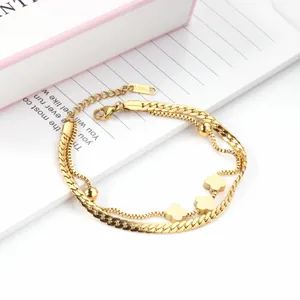 Detailed macro view of golden double-layered clover bracelet with S.STEEL engraving